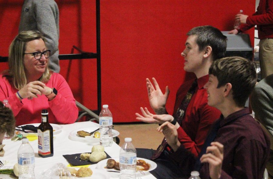Noelle Hinrickson converses with students during the St. Benedict luncheon. This years feast included steak, potatoes, and dinner rolls.