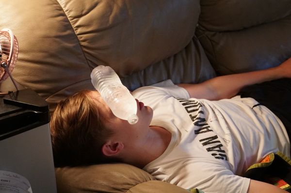 Trying to stay cool, Lincoln Badley 21 uses a frozen water bottle to help ward off the heat in the dorms.