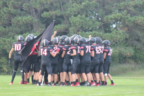 Team Huddle: The Knights storm the field with their traditional waving of the flag. The team is captained by seniors Conor Connealy, Cole Gustafson, Will Brewster, and Jack Huber
