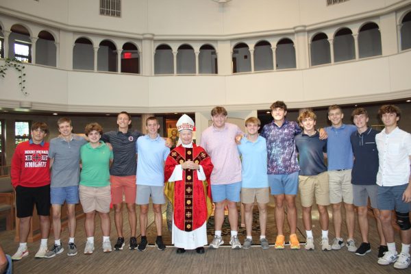 Liturgical Ministers David Schmitz ’25 (fourth from left) poses with Archbishop George Lucas and his classmates after being ordained as litugical ministers. Schmitz and Leo Dustin ’25 (fifth from left) also filled in as alter servers during the celebratory mass.