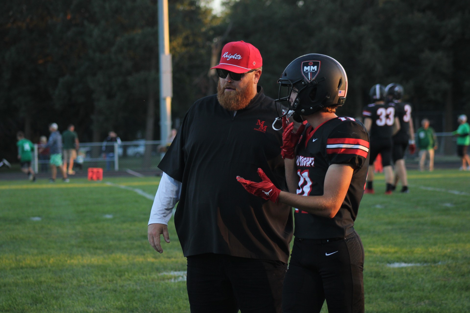 Pregame  Head Coach Jay Landstrom works with Ethan Moline  ‘25 before the Colombus SCOTUS game. The Knights prepared for a tough  game against a top ten team in Class C1.