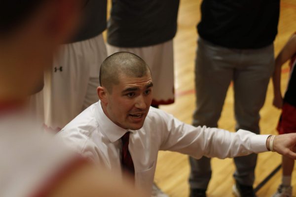 Calling the Shots Former Head Basketball Coach Derrik Spooner coaches the Knights during a 2019 game against Alliance. Spooner coached alongside current history teacher John Roshone '99.