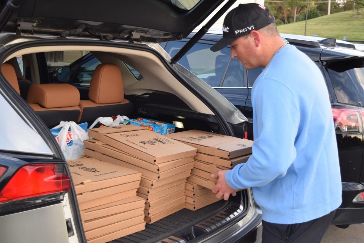 Pizza Time! Director of Enrollement Tim Carlson ‘10 loads La Casa pizzas into his car. Administration collaborated with the boarding program to have a Nebraska watch party with pizzas to benefit the Write to Learn Foundation. Photo courtesy of Rylan Pearson ‘27.